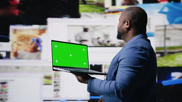 Professional content creator in a multitasking space holds green screen, leveraging social media, internet big data and cloud systems. Engaging followers to boost digital presence. Camera A.