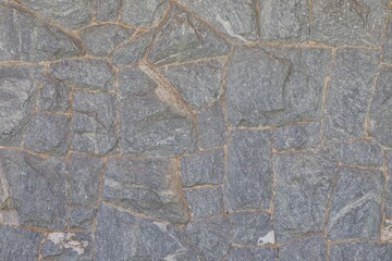 A gray stone wall with a lot of small stones