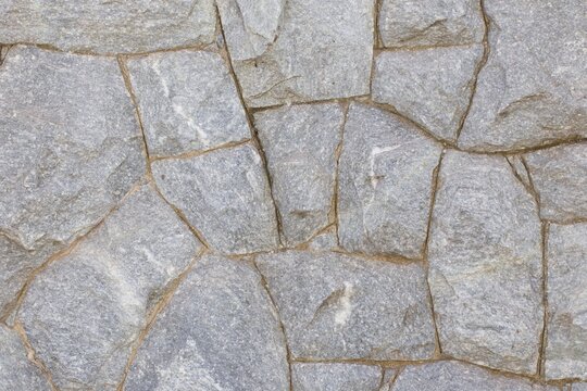 A gray stone wall with a rough texture