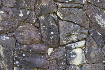 A wall made of stone with moss growing on it