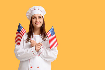 Young female chef with USA flags on orange background