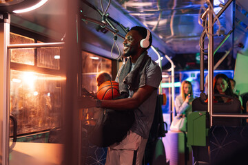Basketball player wearing headphones riding bus at night