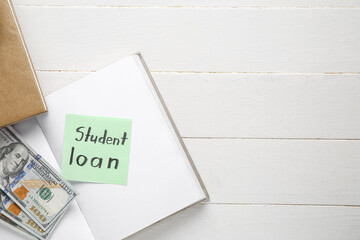Paper sheet with text STUDENT LOAN, book and dollar banknotes on light wooden background