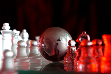 Crystal planet Earth amidst chess pieces showing the American continent, representing concepts of geopolitics, global power, competition for control, international relations, world leaders, struggle f