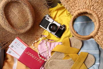 Photo camera, different clothes and beach accessories as background, closeup
