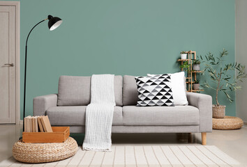 Interior of stylish living room with grey sofa, lamp and green plants