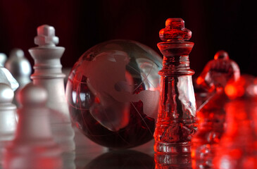 Crystal planet Earth amidst chess pieces showing the American continent, representing concepts of geopolitics, global power, competition for control, international relations, world leaders, struggle f