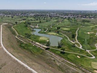 Aerial drone view of a vibrant golf course in Aurora, Colorado, featuring a large lake,...