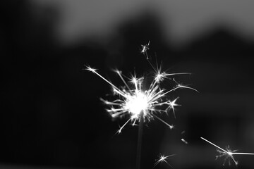 Black and white of ignites handheld firework sparkler as background