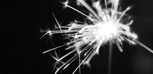 Black and white of ignites handheld firework sparkler as background