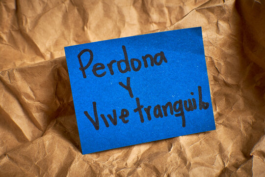 Spanish phrase promoting peace and forgiveness written on a textured background