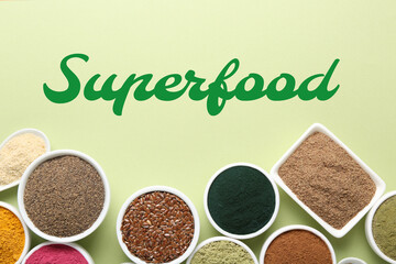 Different superfoods in bowls on light green background, flat lay