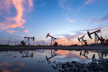 in the evening, oil pumps are running, The oil pump and the beautiful sunset reflected in the...