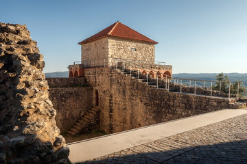 View of the back of one of the bastion towers of the castle of Ourém in Portugal with the blue sky in the background.