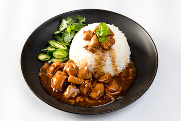 Chicken in brown sauce or gravy sauce with rice  on a black plate - Asian food style