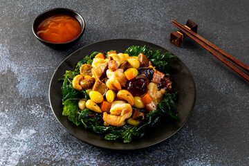 Stir fried mixed Chinese fruits and nuts  on a black plate