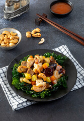 Stir fried mixed Chinese fruits and nuts  on a black plate