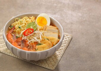 Laksa Singapore is a spicy noodle soup popular in the Peranakan cuisine of Southeast Asia. Laksa consists of thick wheat noodles or rice vermicelli with chicken, prawn or fish, served in spicy soup.