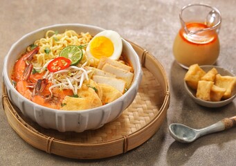 Laksa Singapore is a spicy noodle soup popular in the Peranakan cuisine of Southeast Asia. Laksa consists of thick wheat noodles or rice vermicelli with chicken, prawn or fish, served in spicy soup.