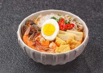 Laksa Singapore is a spicy noodle soup popular in the Peranakan cuisine of Southeast Asia. Laksa consists of thick wheat noodles or rice vermicelli with chicken, prawn or fish, served in spicy soup.