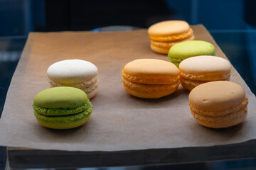 Vibrant Assortment Of French Macarons On Rustic Paper. Colorful French Macarons Displayed On Rustic Paper With A Variety Of Flavors.