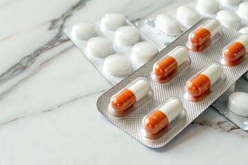 Close-up of assorted pharmaceutical pills in blister packs on a marble countertop