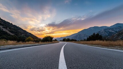 Serene mountain road at sunset leading into majestic horizon