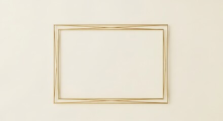 A simple, empty, rectangular, golden frame on a light cream colored wall.