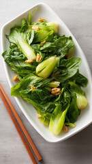 Fresh bok-choy salad with crunchy walnut, served on white plate, healthy green vegetable dish