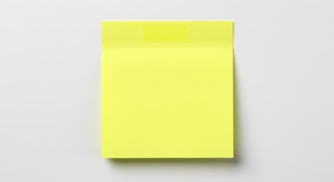 Bright yellow sticky note on a white wall, blank and ready for notes, reminders, or messages with a subtle shadow for depth