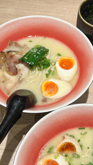 Japanese soup ramen with meat broth asian noodles seaweed sliced pork eggs and ginger on dark...