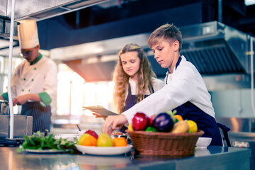 Young chef cooking at restaurant kitchen.