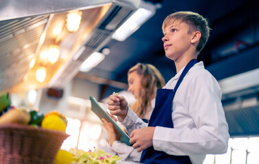Young chef cooking at restaurant kitchen.