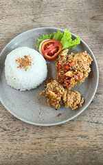 Spicy fried chicken with rice close-up on a plate