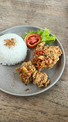 Spicy fried chicken with rice close-up on a plate
