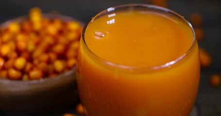 sea buckthorn berries and a glass of juice, a glass of natural orange juice and frozen sea buckthorn berries - Powered by Adobe
