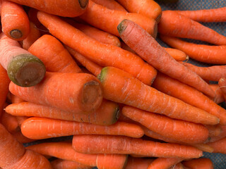 A vibrant close-up shot of freshly harvested, bright orange carrots.