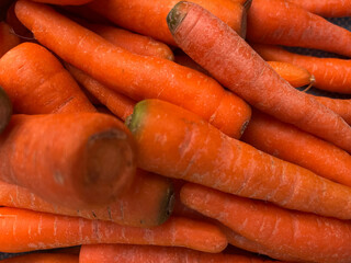 A vibrant close-up shot of freshly harvested, bright orange carrots.