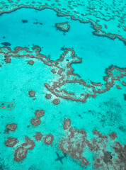 Aerial view of underwater reefs and Heart Reef of the Great Barrier Reef, the world's largest coral reef system with its clear waters, near Whitsundays Islands, Coral Sea, Australia 2020.