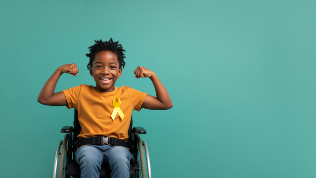 Strong Black boy with yellow ribbon showing biceps. Child cancer survivor in wheelchair flexing muscles on teal background with copy space. Childhood Cancer awareness month. - Powered by Adobe