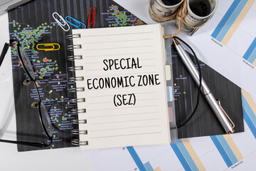 A Note with “Special Economic Zone” Set on the Desk with Graph and Charts – Global Trade...