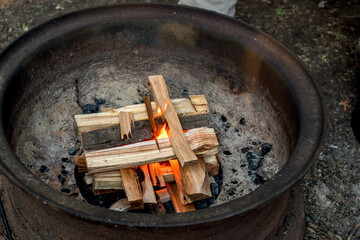 Starting a campfire in a firepit with kindling. Camping lifestyle.