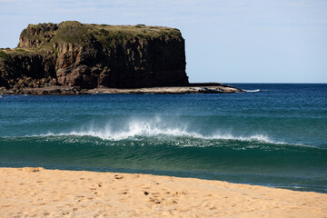 An aqua coloured wave breaks on the shore of Bombo Beach, just north of the scenic tourist town of...
