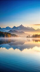 Fototapeta premium Serene lake at dawn with misty mountains in background