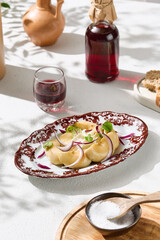 Pickled milk mushrooms with sour cream and red onion, bright daylight, overhead table setting