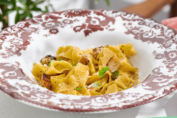 Pappardelle with mushrooms in bright natural light, overhead composition, vintage ceramic plate