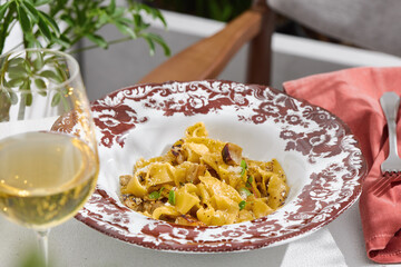 Pappardelle with mushrooms in bright sunlight, overhead composition, elegant rustic table setting