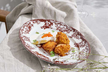Halibut fillet with caviar sauce and potato croquettes, bright natural lighting, overhead composition
