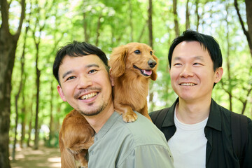 笑顔の男性と犬の楽しい公園散歩