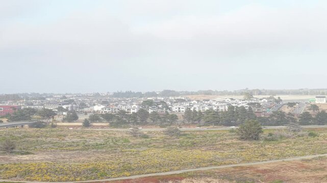 Aerial view captures golden coastline near Fort Ord Beach, with Highway 1 stretching quietly in the distance.